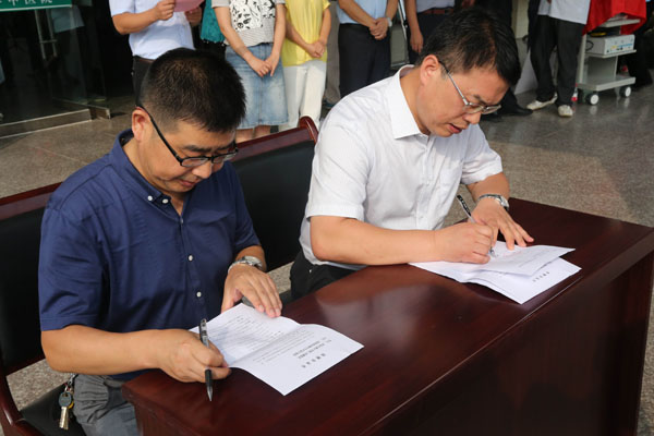 巩守平书记与平利中医院汪院长在捐赠协议上签字.jpg